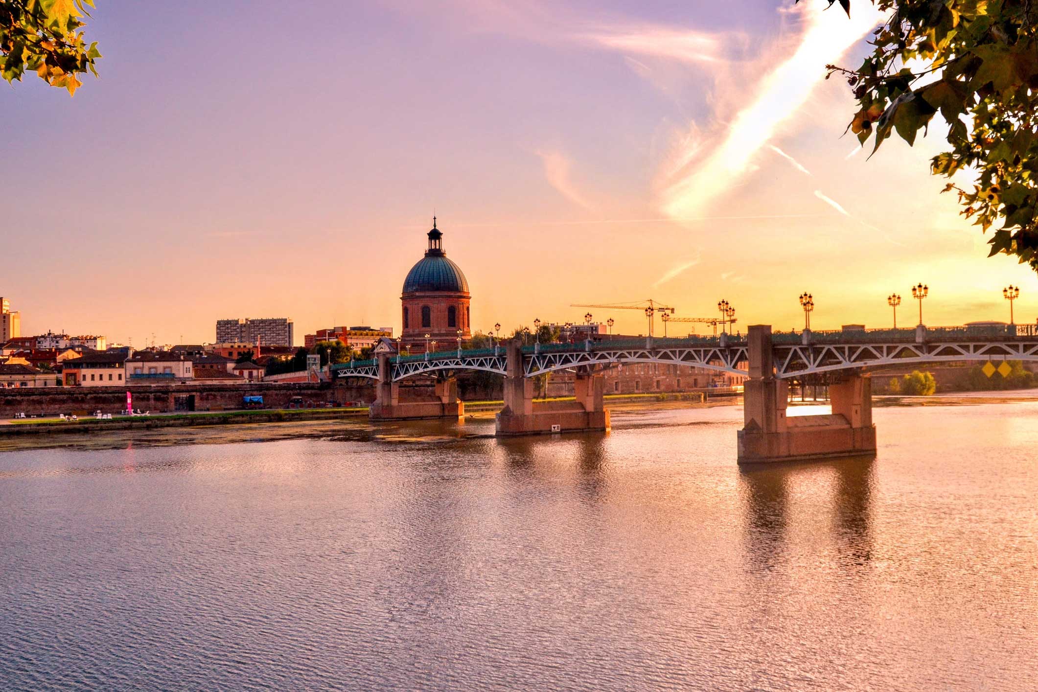 Toulouse au coucher du soleil : le dôme de la Grave et le pont Saint-Pierre sur la Garonne